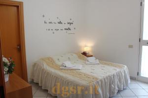 una camera con letto e scrittura a muro di Villa Grazia a Ostuni