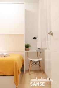 1 dormitorio con cama amarilla y escritorio en Ondarreta Beach by SanSe Holidays, en San Sebastián