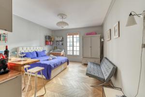 a bedroom with a bed and a table and a chair at Perfect Parisian Apartment LeMarais for you! in Paris