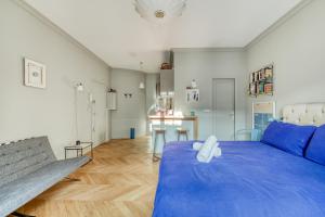 a bedroom with a large blue bed and a bench at Perfect Parisian Apartment LeMarais for you! in Paris