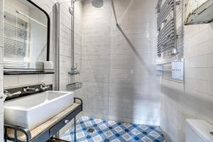 a white bathroom with a sink and a mirror at Perfect Parisian Apartment LeMarais for you! in Paris