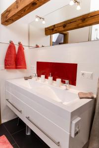 uma casa de banho com um lavatório branco e um espelho vermelho em Ferienhaus Pfalzklause em Billigheim-Ingenheim