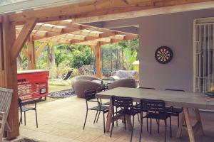 a patio with a table and chairs and a clock at Villa Trésor Péi - Mon îlet in La Possession