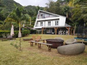 a house with a yard with furniture in front of it at Villa Trésor Péi - Mon îlet in La Possession