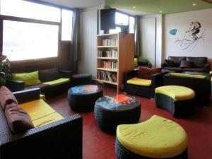 a living room with couches and chairs and a book shelf at VVF Saint-Lary-Soulan Hautes-Pyrénées in Saint-Lary-Soulan