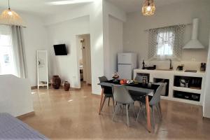 eine Küche und ein Esszimmer mit einem Tisch und Stühlen in der Unterkunft Milos Dream Life in Triovasálos