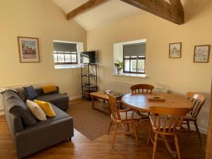 a living room with a couch and a table at The Barn Studio in Millers Dale