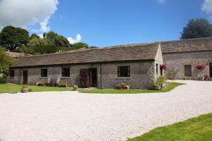 a stone barn with a gravel driveway in front of it at The Barn Studio in Millers Dale