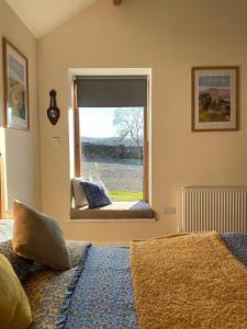 a bedroom with a bed and a window with a view at The Barn Studio in Millers Dale