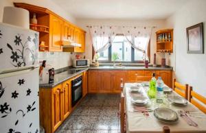 een keuken met een tafel en een witte koelkast bij Casa Rural Yeyo en el cráter del volcán in Tinguatón