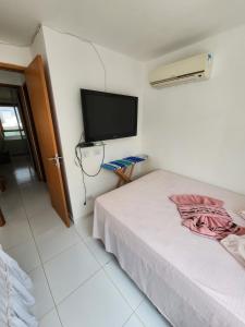 Schlafzimmer mit einem Bett und einem Flachbild-TV in der Unterkunft Village Mediterrâneo in Cabo de Santo Agostinho