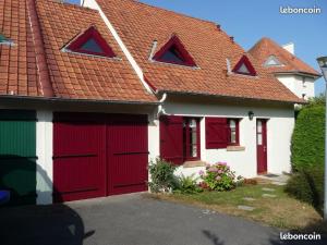 Casa blanca y roja con puertas de garaje rojas en Maison proche centre équestre et forêt avec jardin, en Le Touquet-Paris-Plage