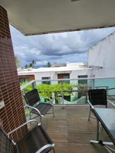 a balcony with chairs and tables on a building at Village Mediterrâneo in Cabo de Santo Agostinho