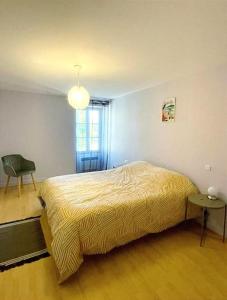 sypialnia z łóżkiem, krzesłem i oknem w obiekcie Gîte Saint Pierre w mieście Verdigny