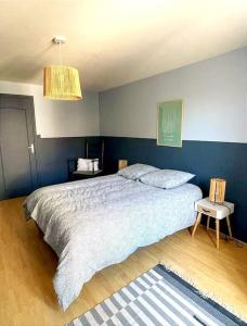 sypialnia z łóżkiem i niebieską ścianą w obiekcie Gîte Saint Pierre w mieście Verdigny