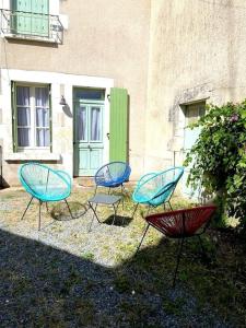 grupa krzeseł siedzących przed budynkiem w obiekcie Gîte Saint Pierre w mieście Verdigny
