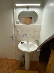 łazienka z białą umywalką i lustrem w obiekcie Gîte Saint Pierre w mieście Verdigny +2 zdjęcia