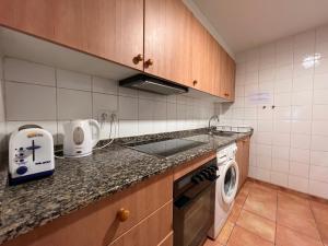a kitchen with a sink and a washing machine at Apartament Boet - Ainet de Cardós in Vall de Cardos