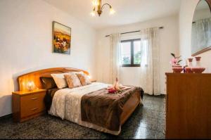 een slaapkamer met een bed, een ladekast en een raam bij Casa Rural Yeyo en el cráter del volcán in Tinguatón