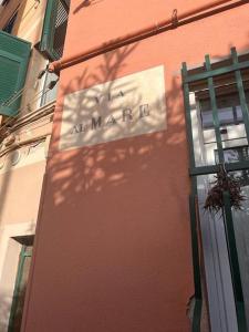 a sign hanging on the side of a building at Casa ORRI by Farris & Cors in Genova