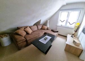 a living room with a brown couch and a table at Ferienwohnung Urlaub über den Second Hand Lädchen in Großbreitenbach