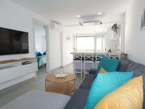a living room with a blue couch and a television at PERLA Penthouse in Gran Tarajal +34 photos