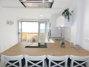 a kitchen and dining room with a wooden table and chairs at PERLA Penthouse in Gran Tarajal