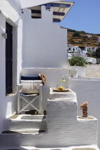 una silla y una mesa en un porche blanco en The Artist House, en Triandáros