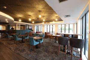 a restaurant with tables and chairs and windows at Knowsley Inn & Lounge in Knowsley