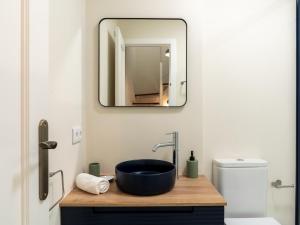 a bathroom with a sink and a mirror at Holi-Rent Penthouse Peñuelas in Seville +47 photos