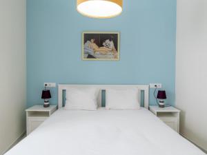 a bedroom with a white bed with two night stands at Holi-Rent Penthouse Peñuelas in Seville