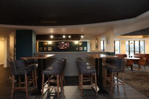 a bar with chairs and tables in a restaurant at Knowsley Inn & Lounge formally Holiday Inn Express in Knowsley