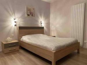 1 dormitorio con 1 cama grande y suelo de madera en Studio avec parking privé au cœur du Tréport, en Le Tréport