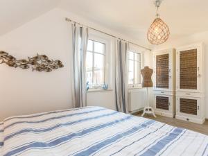 a bedroom with a blue and white bed and windows at Boddenbrise in Bresewitz