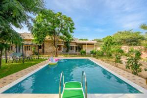 a pool in front of a house with a pool toy at The Bagheera Heritage, Jaipur in Jaipur