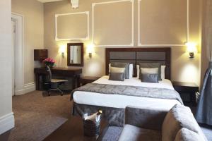 um quarto de hotel com uma cama grande e uma secretária em Gem Strathmore Hotel em Londres