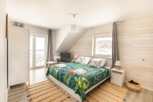 ein Schlafzimmer mit Bett, Stuhl und Fenstern in der Unterkunft Bliżej Nieba in Skrzydlna