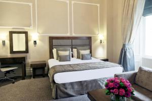 una camera d'albergo con letto e divano di Gem Strathmore Hotel a Londra