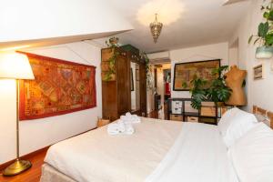都靈的住宿－Porta Nuova APT x4 - City View，一间卧室配有一张带白色床单和一盏灯的床。