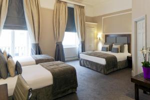 una camera d'albergo con due letti e una finestra di Gem Strathmore Hotel a Londra