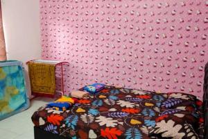 ein Schlafzimmer mit einem Bett und einer rosa Wand in der Unterkunft D'Haja 5 KLIA Sepang with Free Wi-Fi & 3 Airconds in Banting