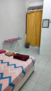 ein Schlafzimmer mit einem Bett und einem Tisch in einem Zimmer in der Unterkunft D'Haja 5 KLIA Sepang with Free Wi-Fi & 3 Airconds in Banting