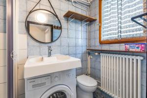 La salle de bains est pourvue d'un lave-linge et d'un lavabo. dans l'établissement Cénoslocs Aulnay - Studio atypique proche de l'aéroport CDG, à Aulnay-sous-Bois
