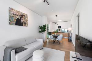 ein weißes Wohnzimmer mit einem Sofa und einem Esszimmer in der Unterkunft Design apartment with amazing view over Vienna in Wien