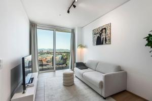 a living room with a couch and a large window at Design apartment with amazing view over Vienna in Vienna