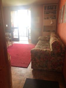un soggiorno con divano e tappeto rosso di Gressoney Saint Jean, Italy a Gressoney-Saint-Jean