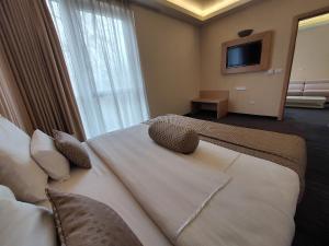 فندق سبا تيرمي في سراييفو: سرير كبير في غرفة الفندق مع تلفزيون