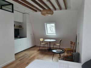 una cucina e un soggiorno con tavolo e sedie di Chambre d'hôtes confort et charme Paris 9eme a Parigi