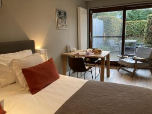 um quarto com uma cama e uma mesa com uma sala de jantar em B&B De Tuinkamer em Knokke-Heist