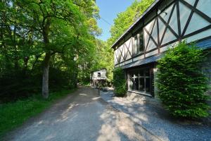 une route vide devant un bâtiment planté d'arbres dans l'établissement Gite Fond des Vaulx, à Marche-en-Famenne